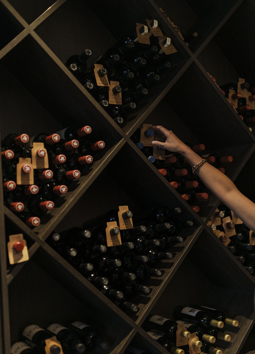 Selecting a bottle from the TOAST & OAK wine cellar